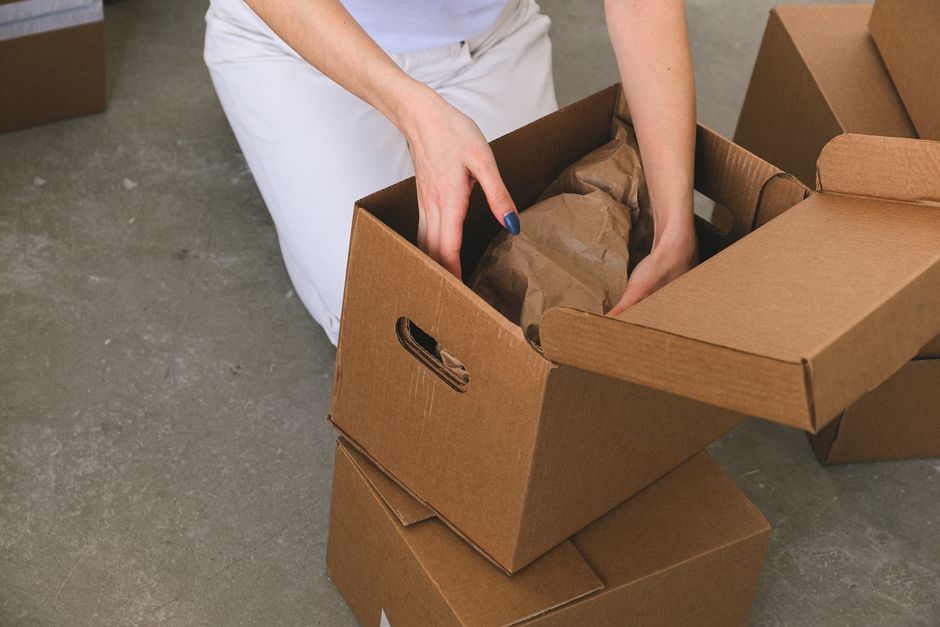 Movers packing cardboard moving boxes safely