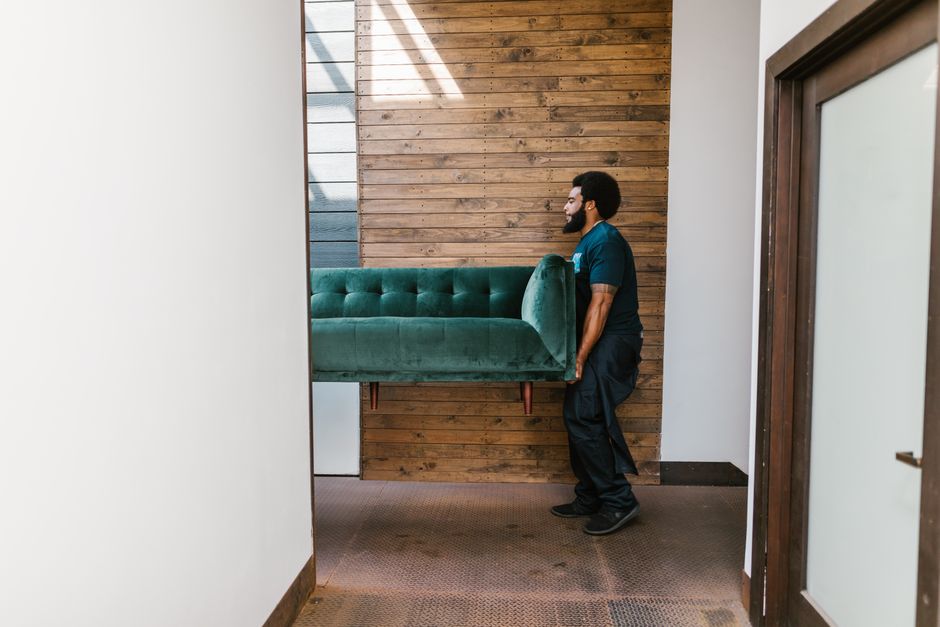 Professional movers carrying heavy furniture carefully